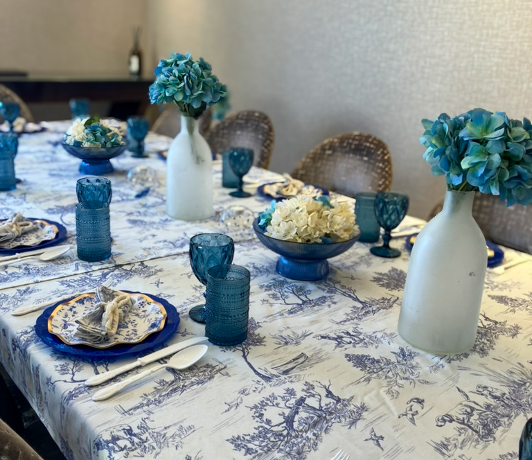 Styled birthday table with blue toile accents and glassware for a 60th celebration